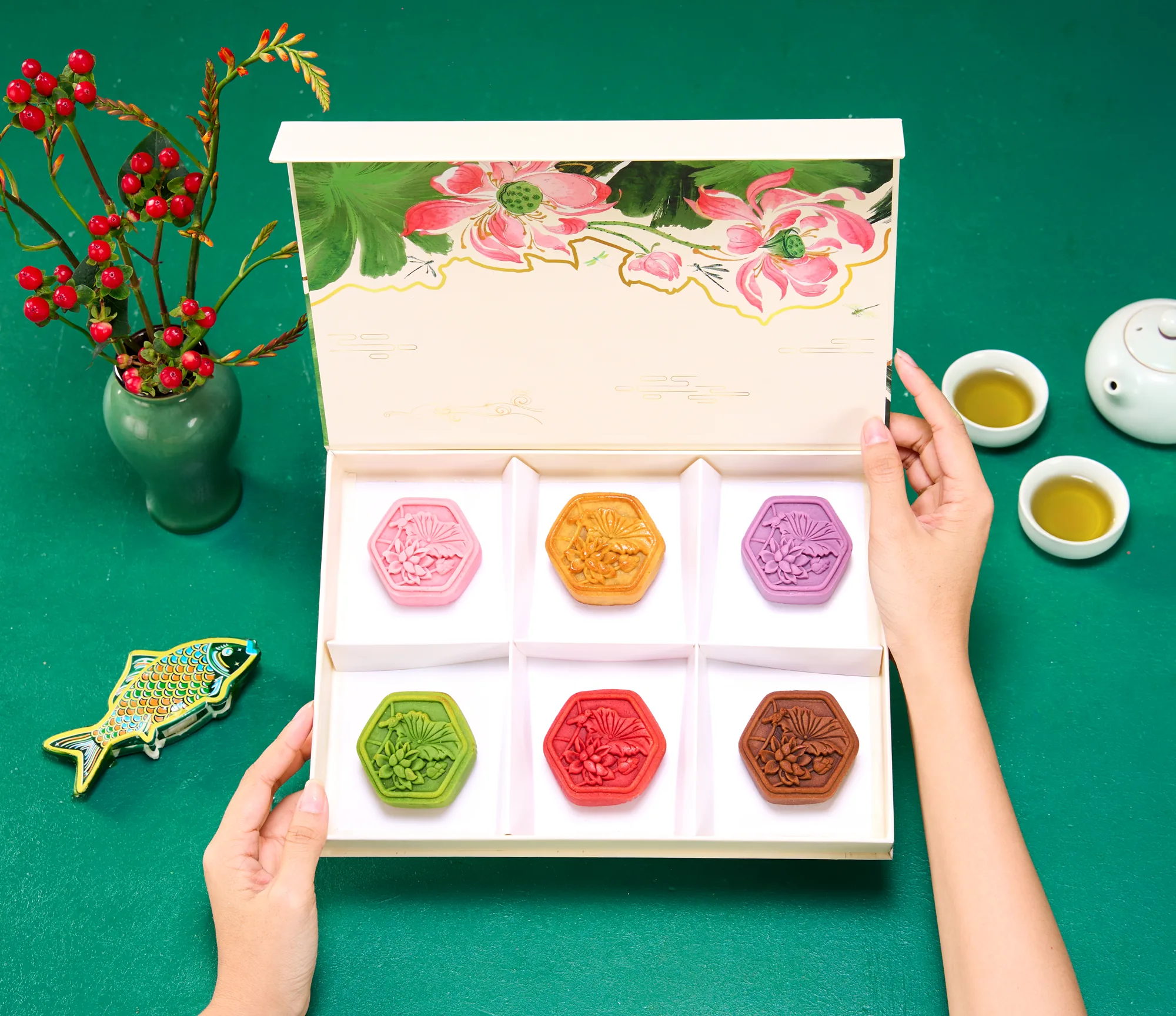 Đôi tay mở hộp bánh nhiều màu